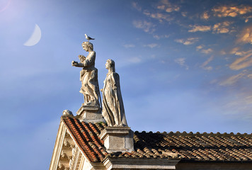 Obraz premium Starożytne rzeźby na szczycie włoskiego budynku w Rzymie