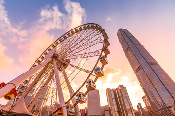 Das beliebte Symbol Observation Wheel in Hong Kong Island bei Sonnenuntergang in der Nähe von Ferry Pier arera mit markanten Gebäuden im Hintergrund.