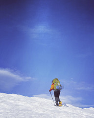 Winter hiking in the mountains on snowshoes with a backpack and