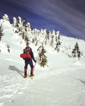 Winter hiking in the mountains on snowshoes with a backpack and