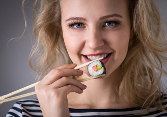 Young woman holding sushi rolls