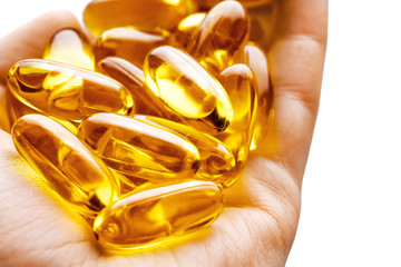 Hand is giving Omega 3 capsules on white background. Palm up, close up. High resolution product.