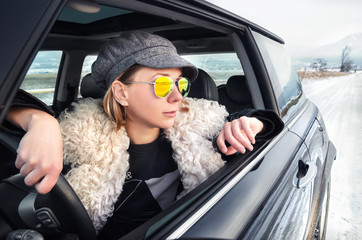 Hipster woman sitting in a small car