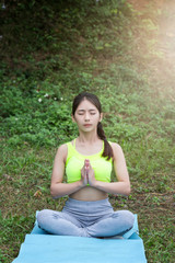 Fototapeta premium Young asian woman in sportswear meditating on yoga mat
