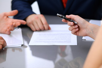 Business lady offering businessman black pen for signing a contract