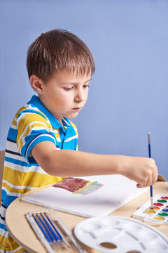 Child painting with aquarelles.