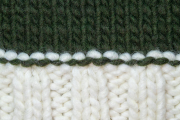 knitted background white and dark green. Wool yarn winter.