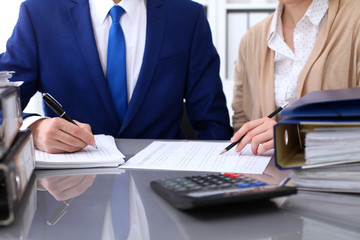 Fototapeta premium Bookkeeper or financial inspector and secretary making report, calculating or checking balance. Internal Revenue Service inspector checking financial document. Audit concept.
