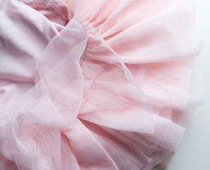 High angle c;lose up view of little girl's pink tutu on white table
