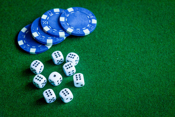 poker chips and dice on green background top view
