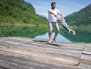 Dad and son playing on the mountain lake