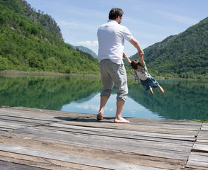 Dad and son playing on the mountain lake