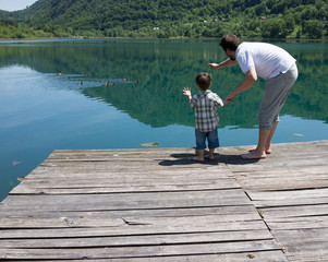 Dad and son playing on the mountain lake