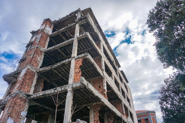 Low angle view of damaged building against cloudy sky