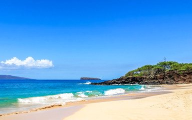 Fototapeta na wymiar Tropical Hawaiian beach location on Maui, Hawaii. Warm ocean water breaking onto sandy beaches. Tourist travel destination location.