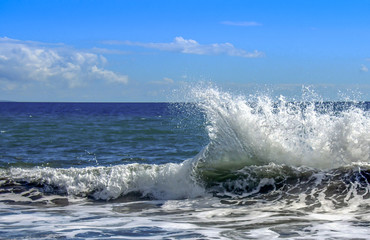 Tropical ocean beach waters splashing and crashing onto the beach.  Sea foam and sparkling water with splash rising into the air. 