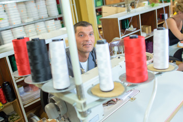 Man behind spools of cotton