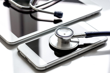 diagnostic of gadgets on white background with stethoscope