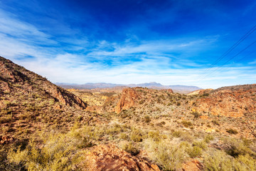 Four Peaks Mountains in the distance behind the red rocky landscape running by the Apache Trail through the Tonto National Forest Arizona