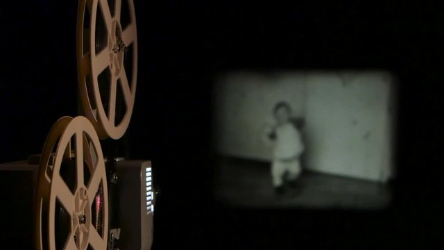 Vintage projector translates old film on the screen. Close up