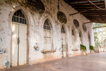 Horizontal photo in color, perspective and shallow depth of field, about an old white hacienda facade