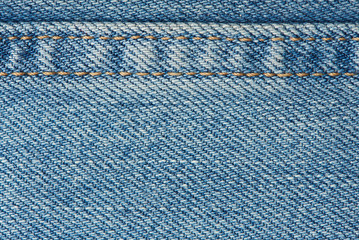 Stitches on light blue jeans background