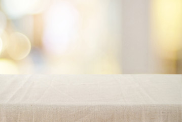 Empty table with linen tablecloth over blurred store with bokeh