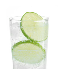 Full glass of fresh cool tonic with lime fruits isolated on whit