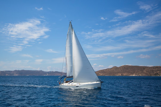 Luxury yacht at regatta. Sailing in the wind through the waves at the Aegean Sea.