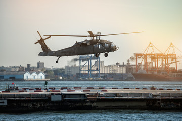 Military helicopter landing on heliport in New York City.