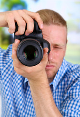 Handsome photographer with camera,on bright background