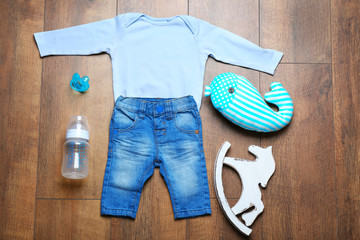 Baby clothes and necessities on wooden background