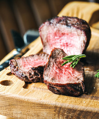 Beef steak with rosemary on a wood cutting board