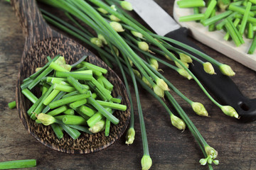 bunch of fresh chives on a wooden cutting board