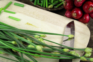 bunch of fresh chives on a wooden cutting board