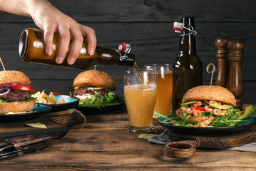 Lager beer on wooden table with a variety of burgers