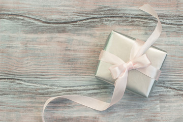 Elegant gift box in silver paper with a pink ribbon