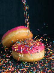 Pink donuts sprinkling with candy sticks