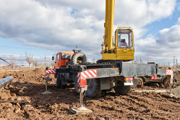 Laying of the main pipeline in the field using a crane. The work is carried out in the impassable mud