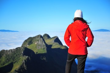 Fototapeta na wymiar Young Woman on Mountain Peaks