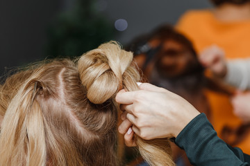 professional hairdresser doing a hairstyle to her client with he