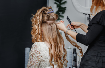 Stylist at work makes hair to model sandy blonde.