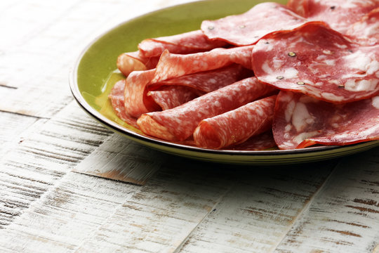 Chorizo sausage and salami, thin cut. spanish salami on the wood background with spices,  Spicy food. 