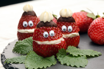 Christmas strawberry Santa. Funny dessert stuffed with whipped cream. Xmas party food idea