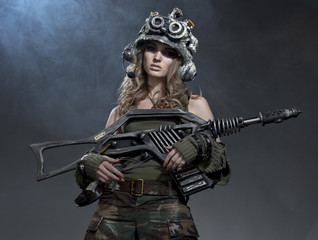Obraz na płótnie Canvas Very beautiful girl - soldiers - the future, with an unusual gun in his hand