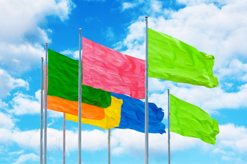 Colorful flags in wind against cloudy sky