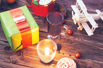 Gift box, christmas decorations and mulled wine on wooden table.