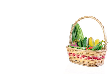 Vegetables and fruits in wicker basket isolated on white background.

