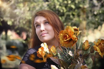 the girl with red hair posing in the Park with a bouquet of flowers