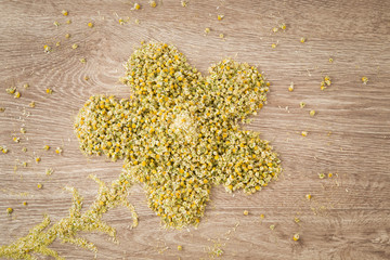 Dried chamomile herbal tea in flower form. Chamomile tea in the burlap bag on the wooden table. Healthy lifestyle.